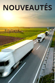 Une autoroute avec un série de camions blancs en pleine campagne.